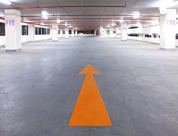 Empty parking garage with yellow arrow