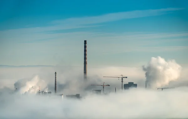 Factory chimneys and clouds of steam
