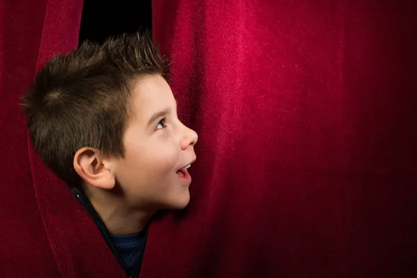 Child appearing beneath the curtain