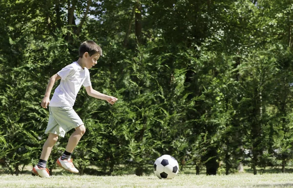 Child playing football in a stadium