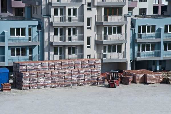 Pallets of bricks in front of new building