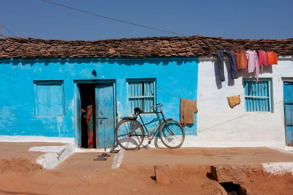 Traditional indian house of blue color with a bicycle