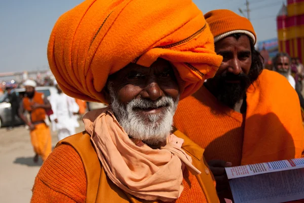 Elderly indian pilgrim in orange turban on the celebration Kumbh Mela