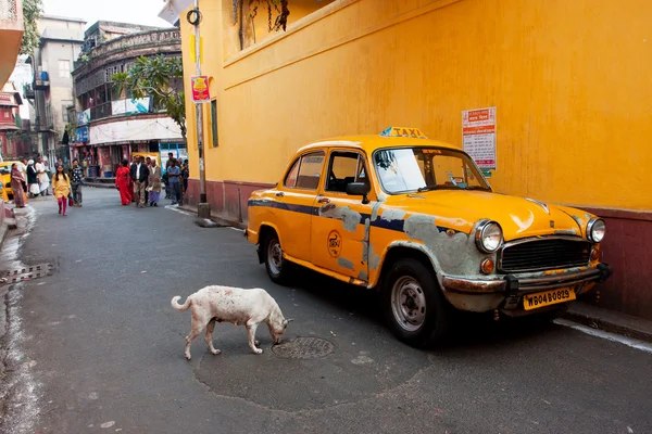 Antique yellow taxi cab stoped on a narrow street