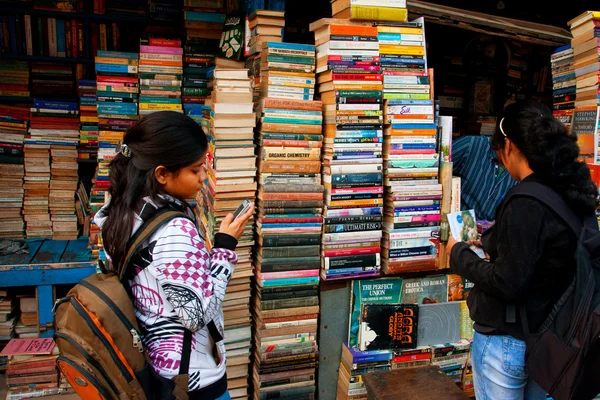 Young female student choose the book on the street market