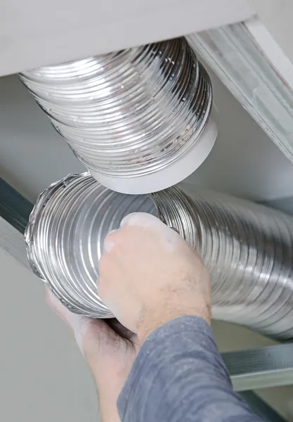 Male hands setting up ventilation system indoors