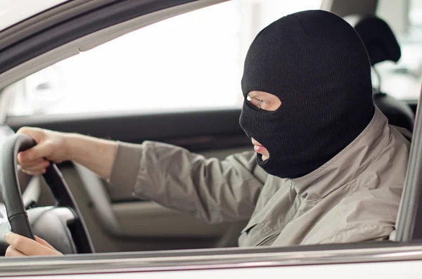 Thief in mask steals expensive new car.