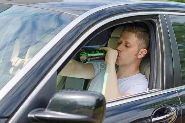 Driving Under the Influence. Man drinking alcohol in the car.