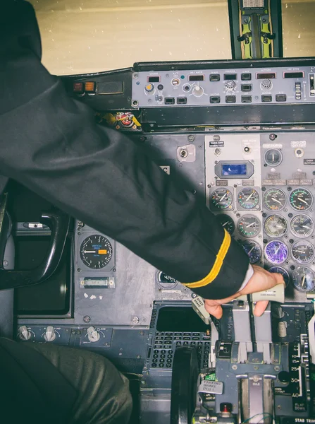 Rear view of pilot in aircraft cabin.