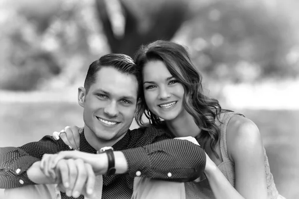 Black and White version of a happy young couple posing seated on