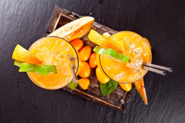 Summer orange cocktails on black stone