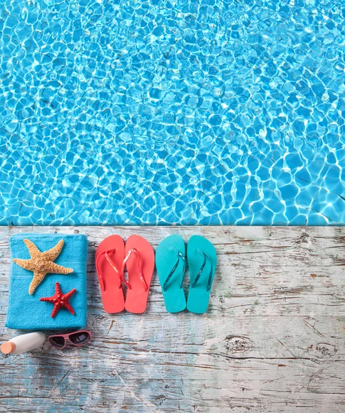Summer accessories on wood with swimming pool surface
