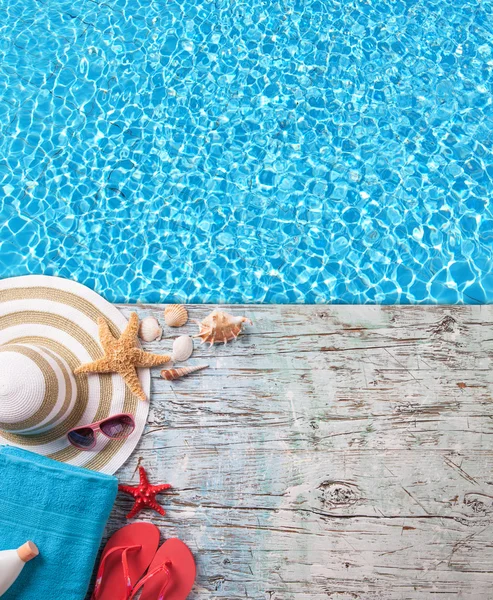 Summer accessories on wood with swimming pool surface