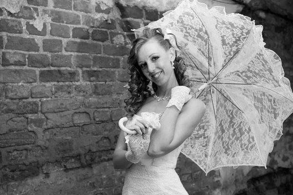 Beautiful bride in white dress with umbrella