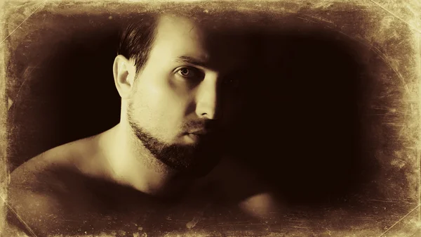 Vintage-like low key male portrait with beard and hairy shoulder