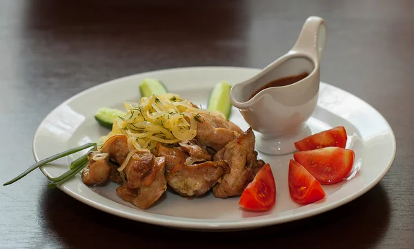 Shish kebab from chicken with sauce tomatoes and cucumbers