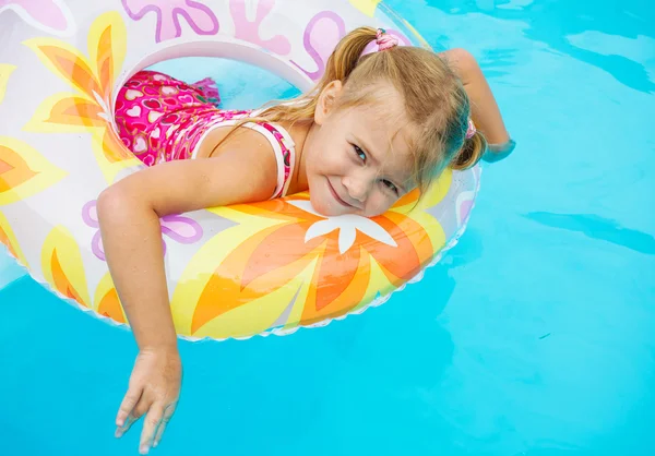 Little girl in the pool with rubber ring