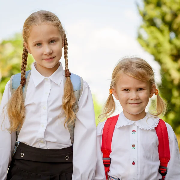 Two young little girls preparing to walk to school