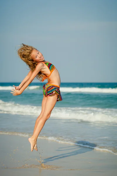 Flying jumping beach girl at blue sea shore in summer vacation i