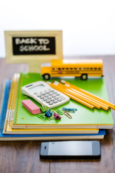 School supplies, pencils, toy school bus, note book, calculator