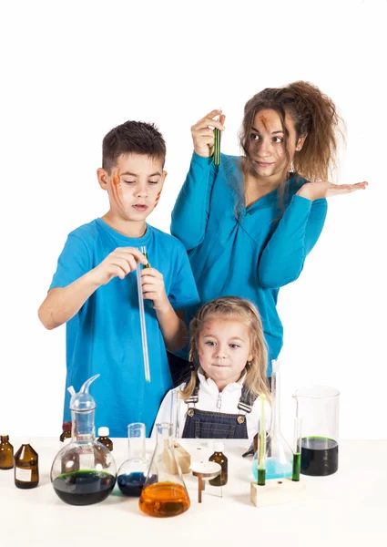 Three children working with chemical liquids at lesson