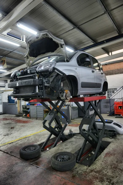 Car in garage with special equipment prepared for repair