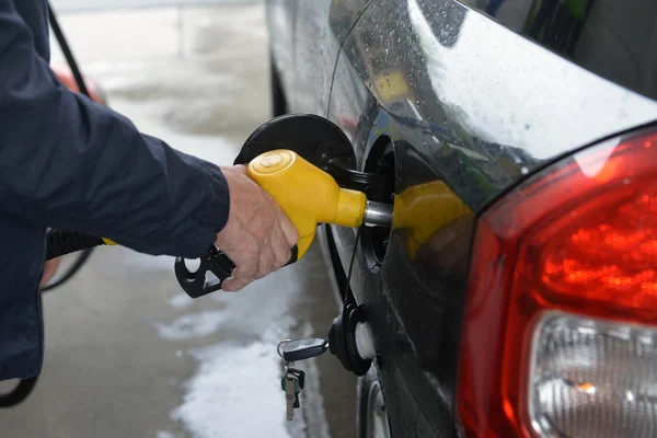 Man hand refilling up gas tank