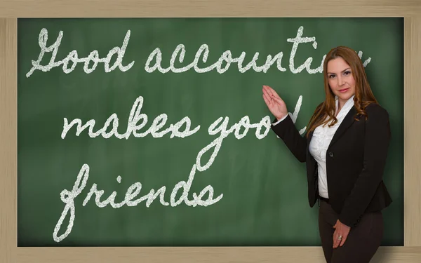 Teacher showing Good accounting makes good friends on blackboard