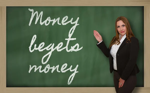 Teacher showing Money begets money on blackboard