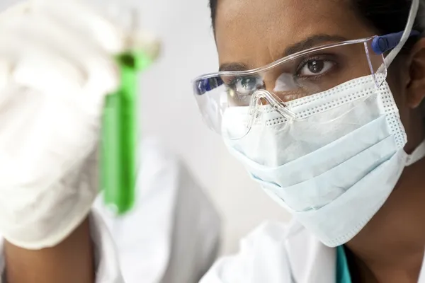 Asian Female Scientist or Doctor With Green Solution In Laborato