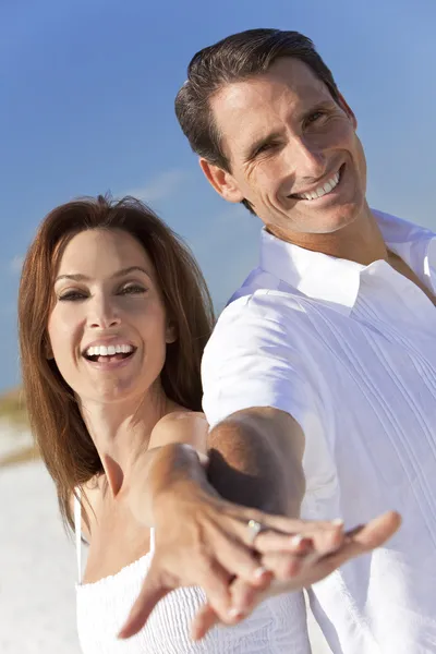Attractive Couple Laughing Holding Hands on A Beach