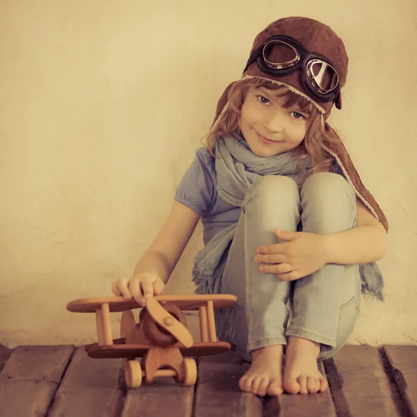 Happy kid playing with toy airplane