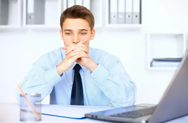 Young pensive businessman in office