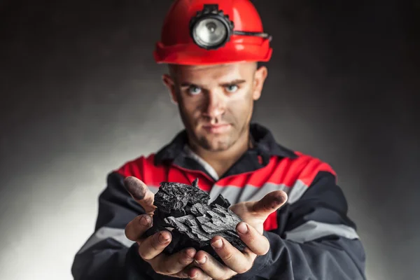 Coal miner holding lump of coal