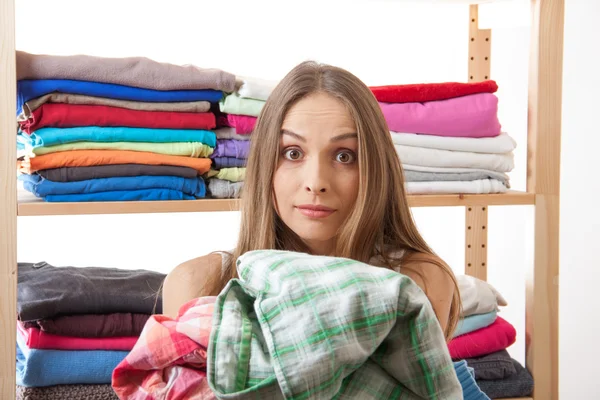 Young woman holding a pile of clothes