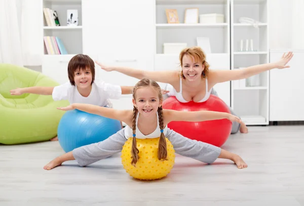 Happy kids exercising with their mother