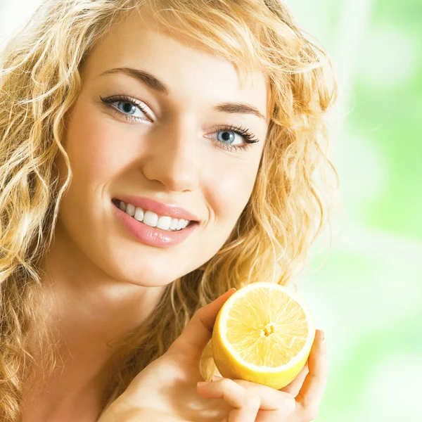 Young happy smiling woman with lemon