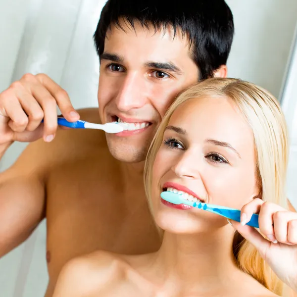 Cheerful young couple cleaning teeth together
