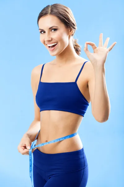 Woman in fitness wear with tape, over blue