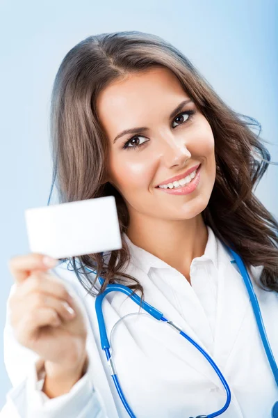 Young female doctor showing blank business card
