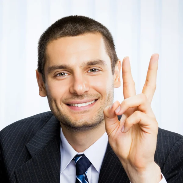 Businessman showing two fingers or victory gesture