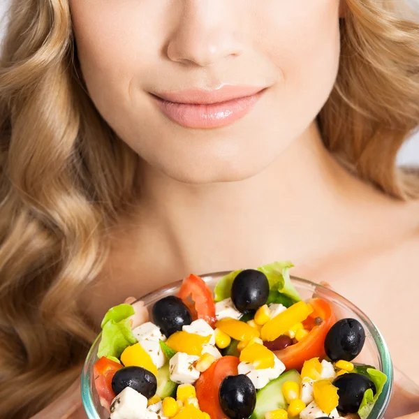 Woman with vegetarian salad, over gray