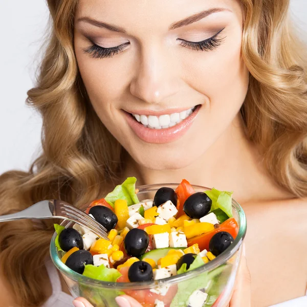 Woman with vegetarian salad, over gray