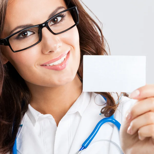 Young female doctor showing blank business card