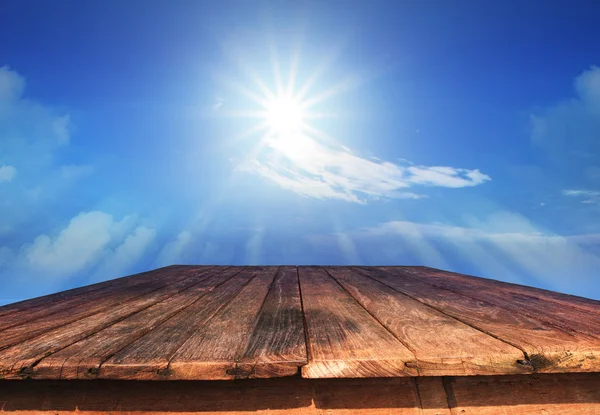 Old wood table and sun shine on blue sky