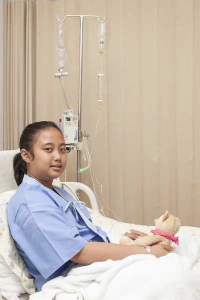 Girl lying on patient bed on hospital treatment room waiting for doctor