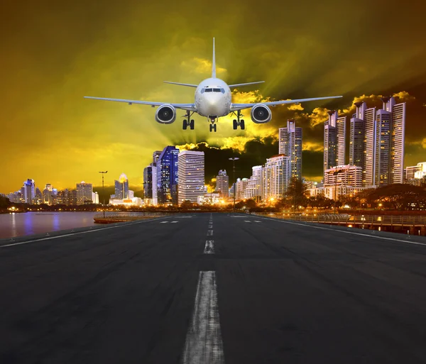 Passenger air plane landing in urban airport against sunset and beautiful dramatic sky use for transportation by aircraft and transport business theme