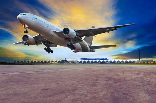 Passenger jet plane landing on air port runways against beautifu