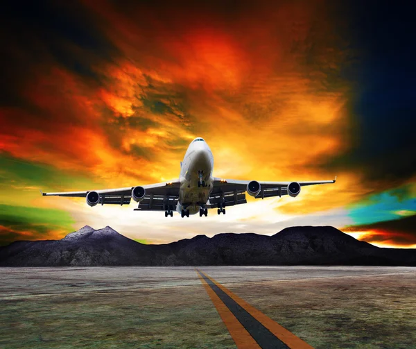 Jet plane flying over runways against rock mountain and beautiful dusky sky with copy space use for air transport ,journey and traveling industry business