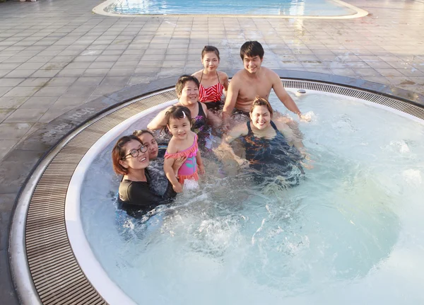 Big family people and brothers relaxing in water pool with happ